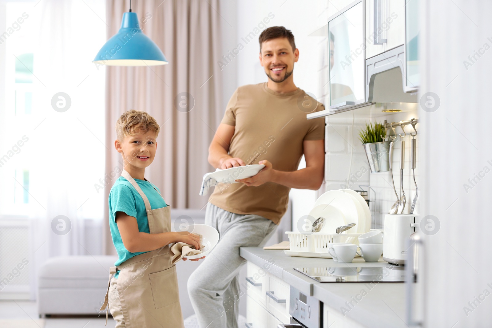 Photo of Dad and son wiping dishes in kitchen