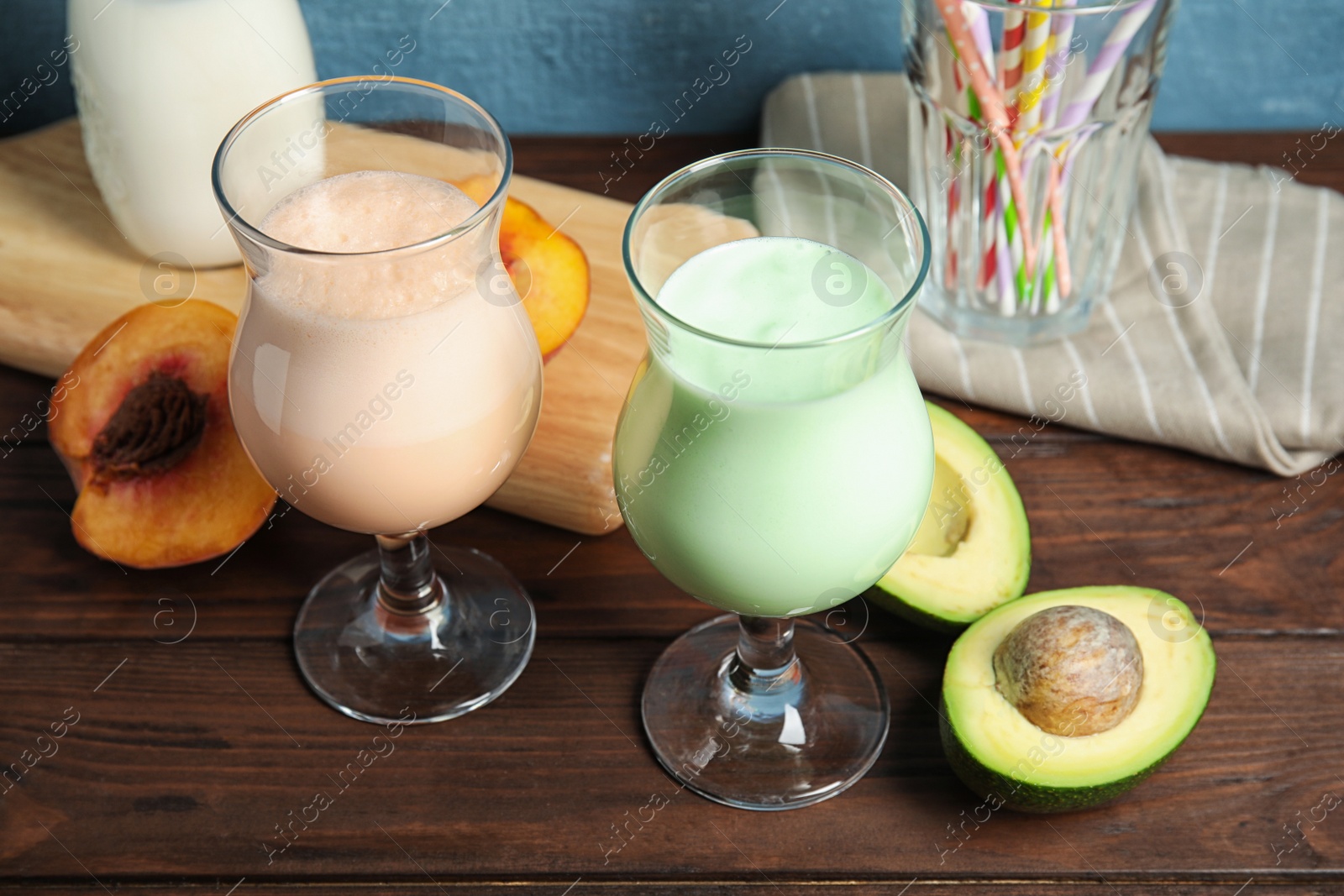 Photo of Glasses with delicious milk shakes and ingredients on table