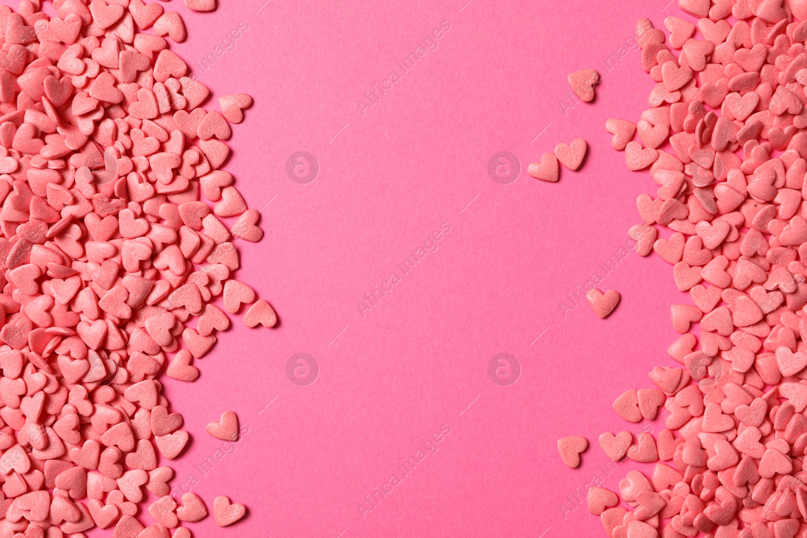 Photo of Heart shaped sprinkles on pink background, flat lay. Space for text