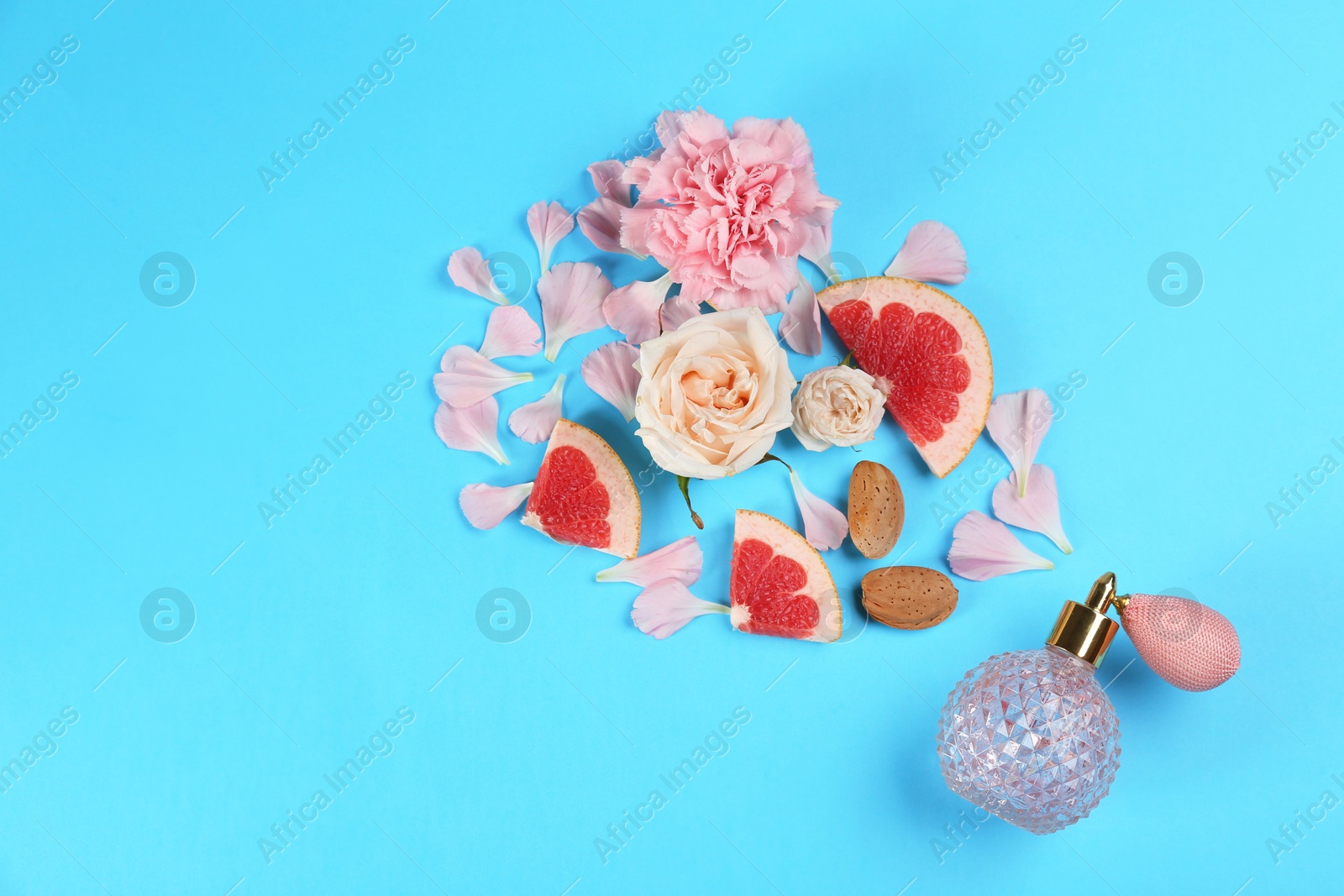 Photo of Flat lay composition with bottle of perfume on light blue background