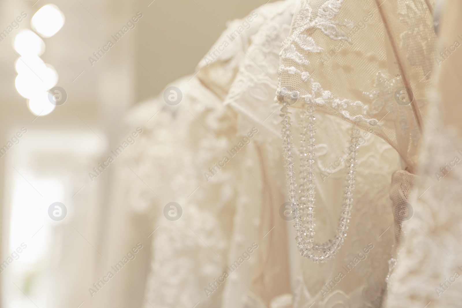 Photo of Beautiful wedding dresses with lace in salon, closeup