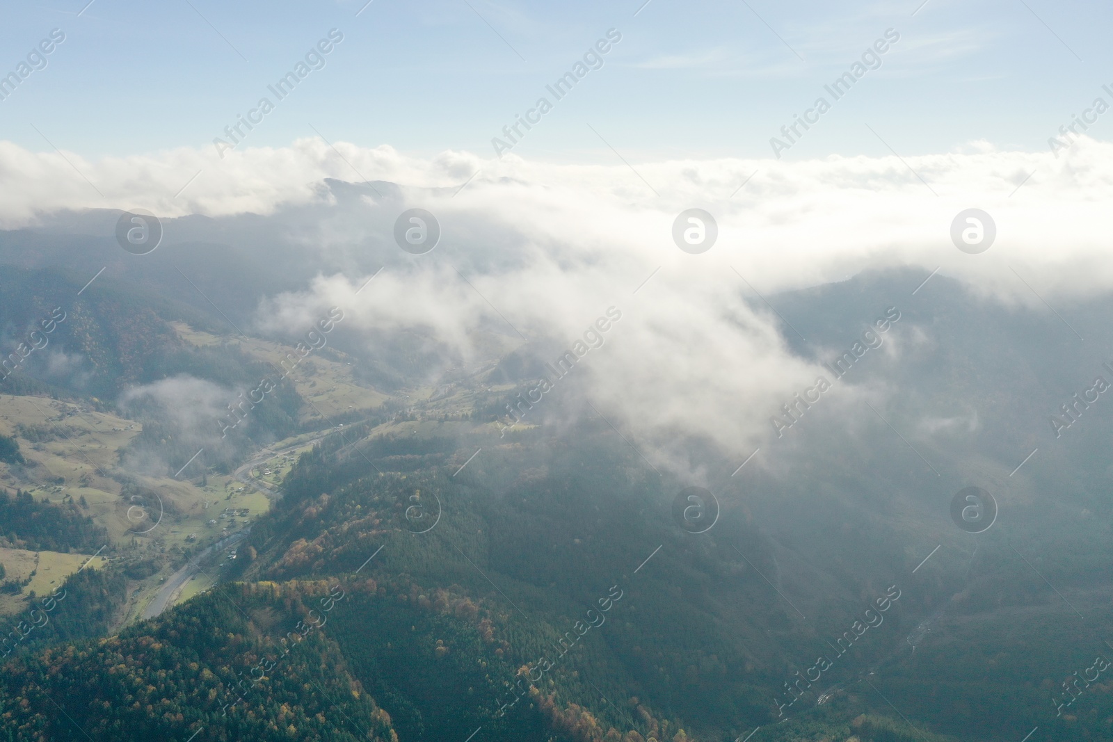Photo of Aerial view of fluffy clouds over mountain forest