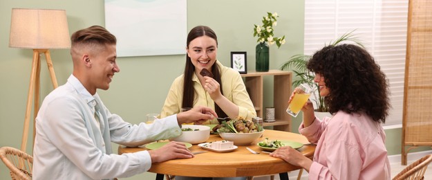 Friends having vegetarian meal at table in cafe