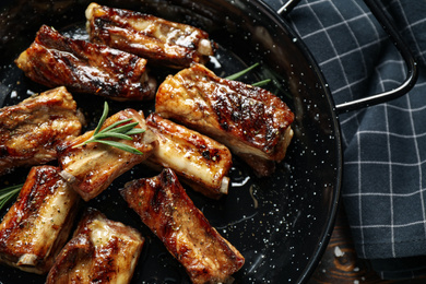 Photo of Delicious grilled ribs with rosemary on table, closeup view