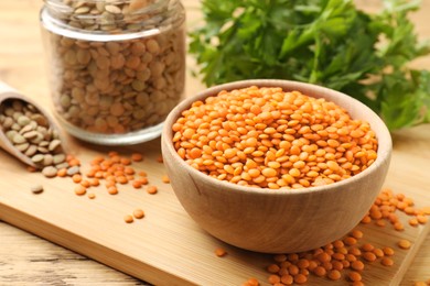 Photo of Different types of lentils on wooden table, closeup