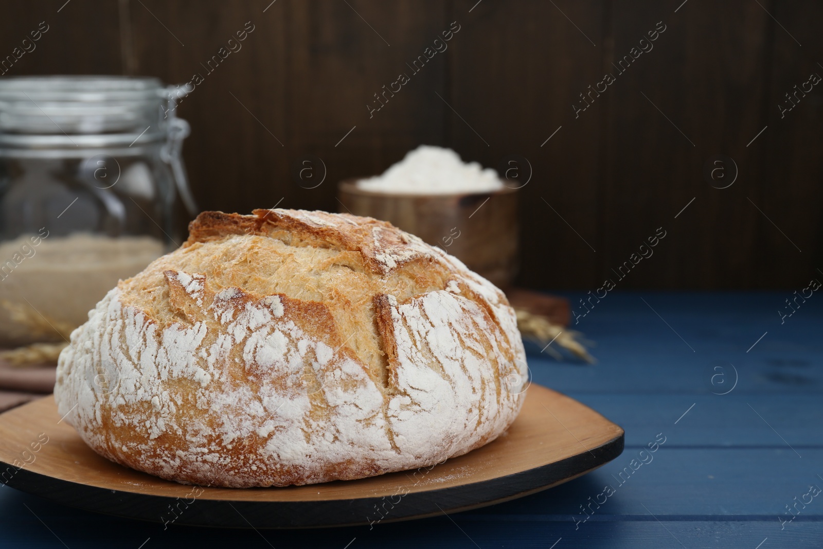 Photo of Freshly baked bread on blue wooden table. Space for text
