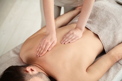 Handsome man receiving back massage in spa salon, closeup