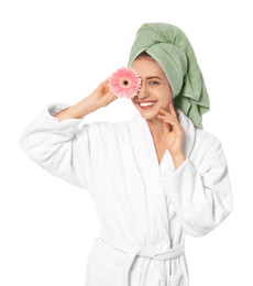 Beautiful young woman with flower wearing bathrobe on white background