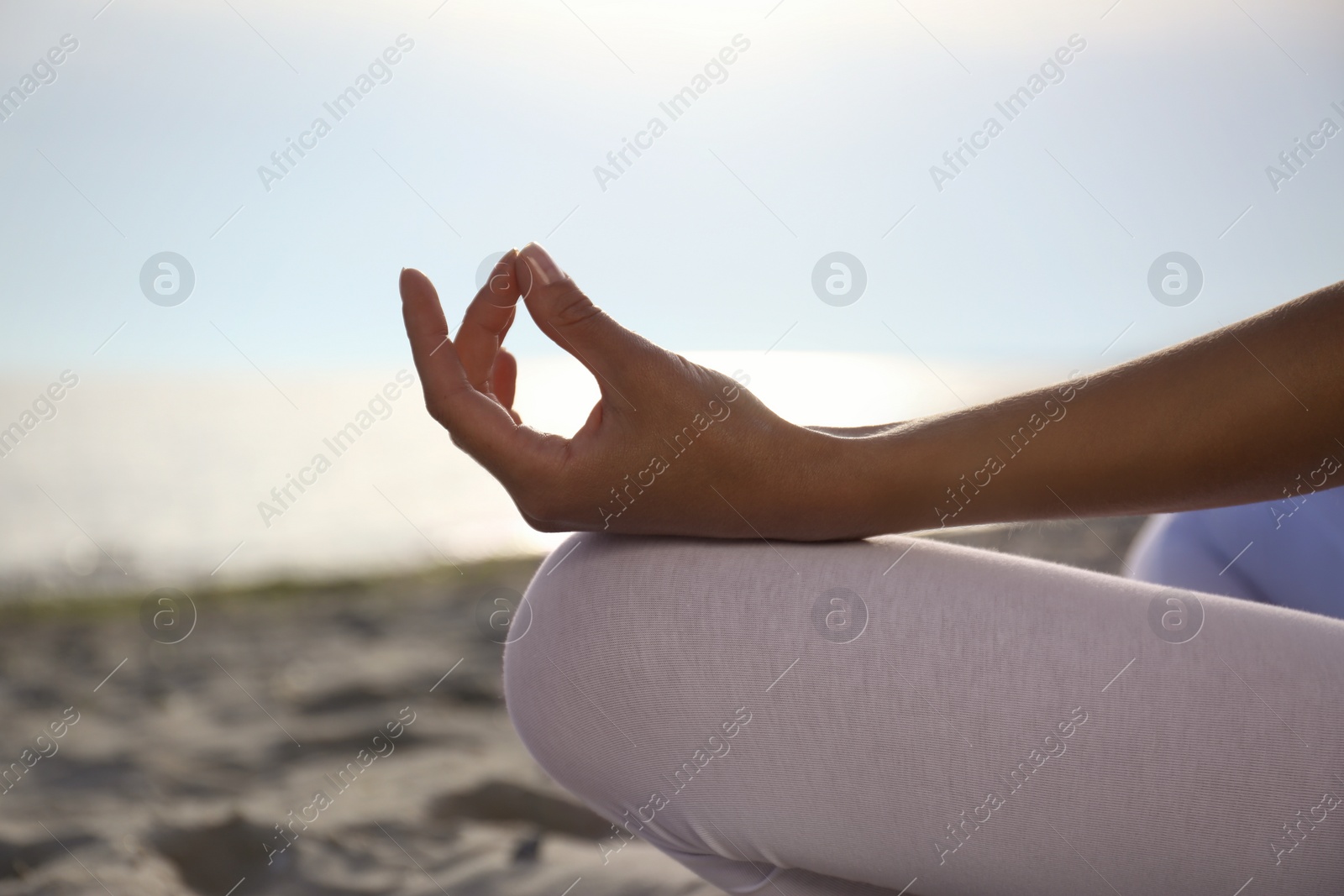 Photo of Young woman practicing zen meditation on beach, closeup. Space for text