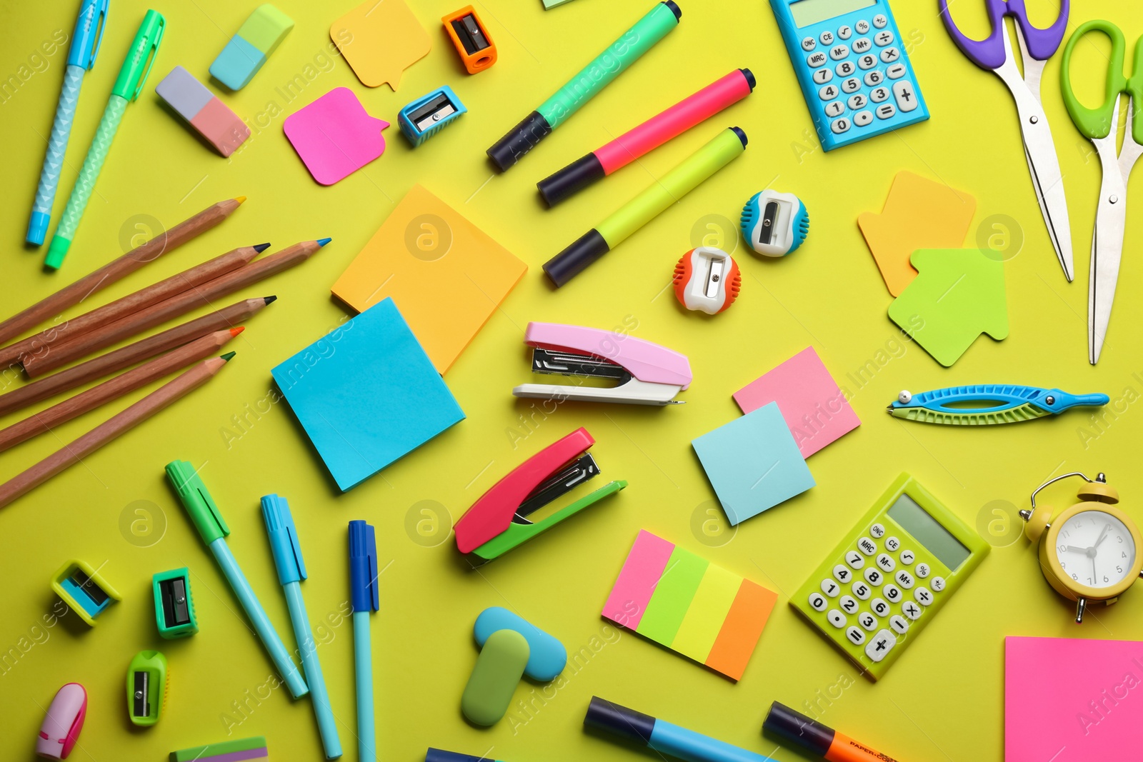 Photo of School stationery on yellow background, flat lay. Back to school