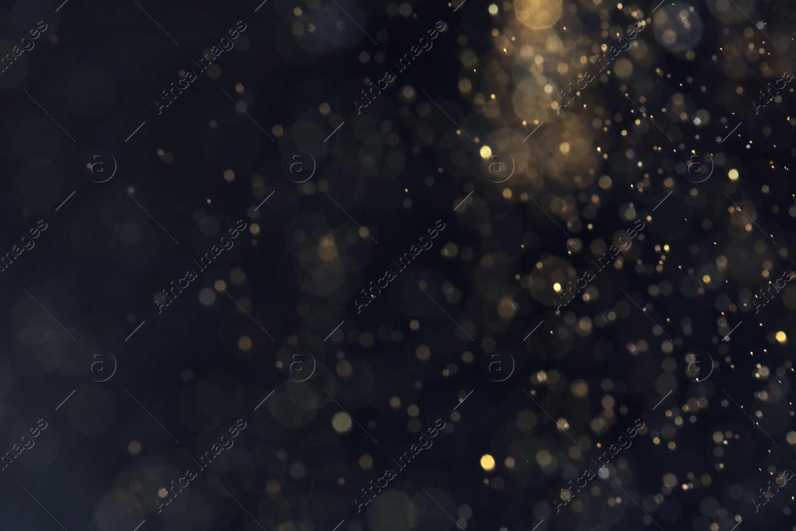 Photo of Golden glitter with bokeh effect on dark background