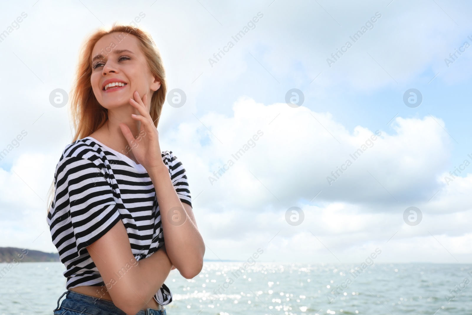 Photo of Beautiful young woman near sea on sunny day in summer, space for text