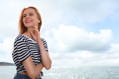 Photo of Beautiful young woman near sea on sunny day in summer, space for text