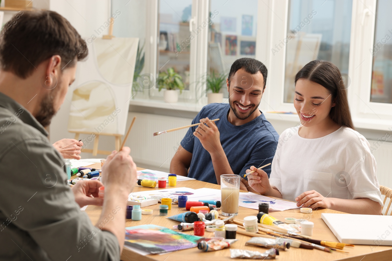 Photo of Group of students attending painting class in studio. Creative hobby