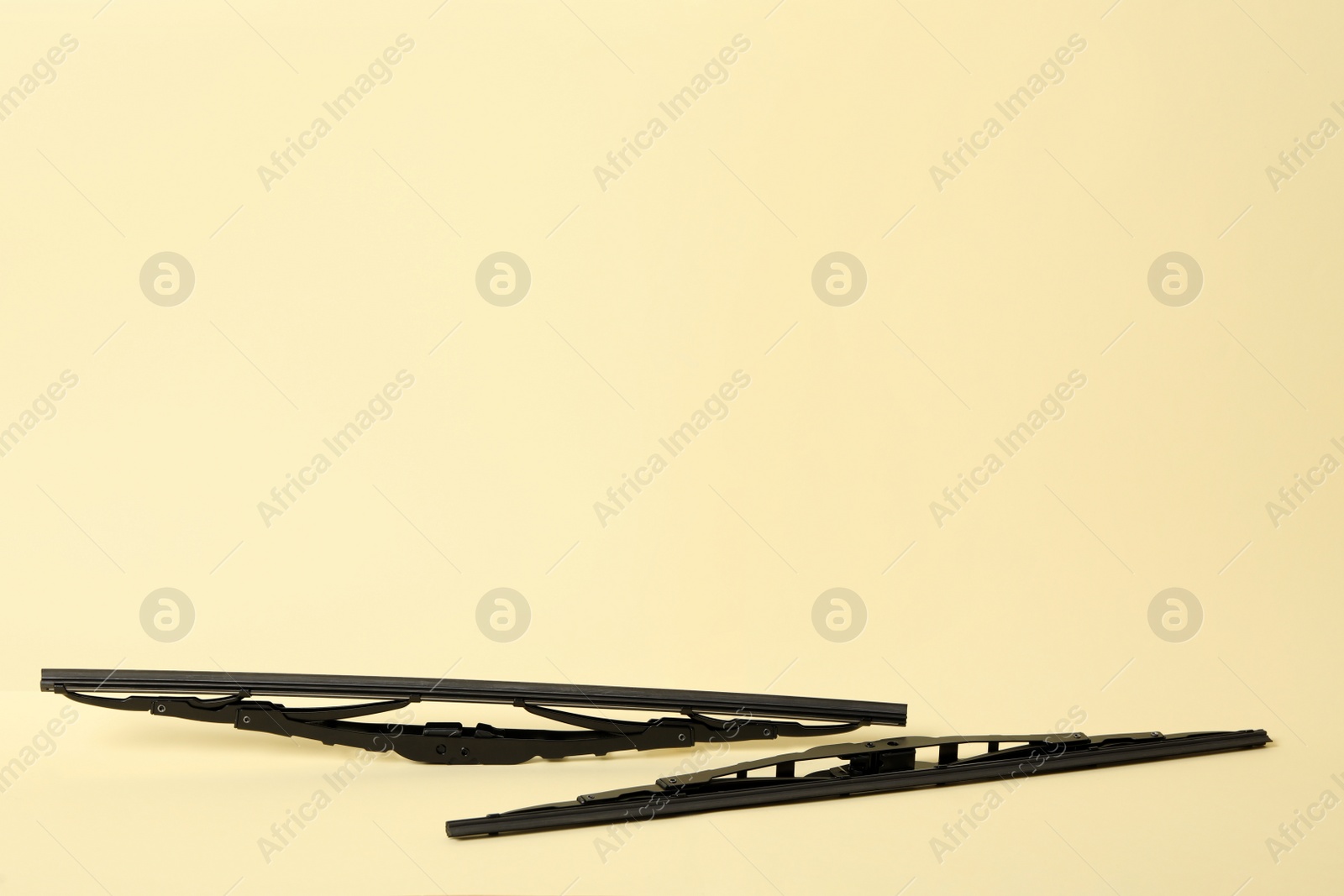 Photo of Car windshield wipers on beige background. Space for text