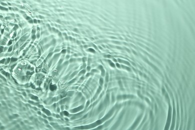 Image of Rippled surface of clear water on aquamarine background, top view