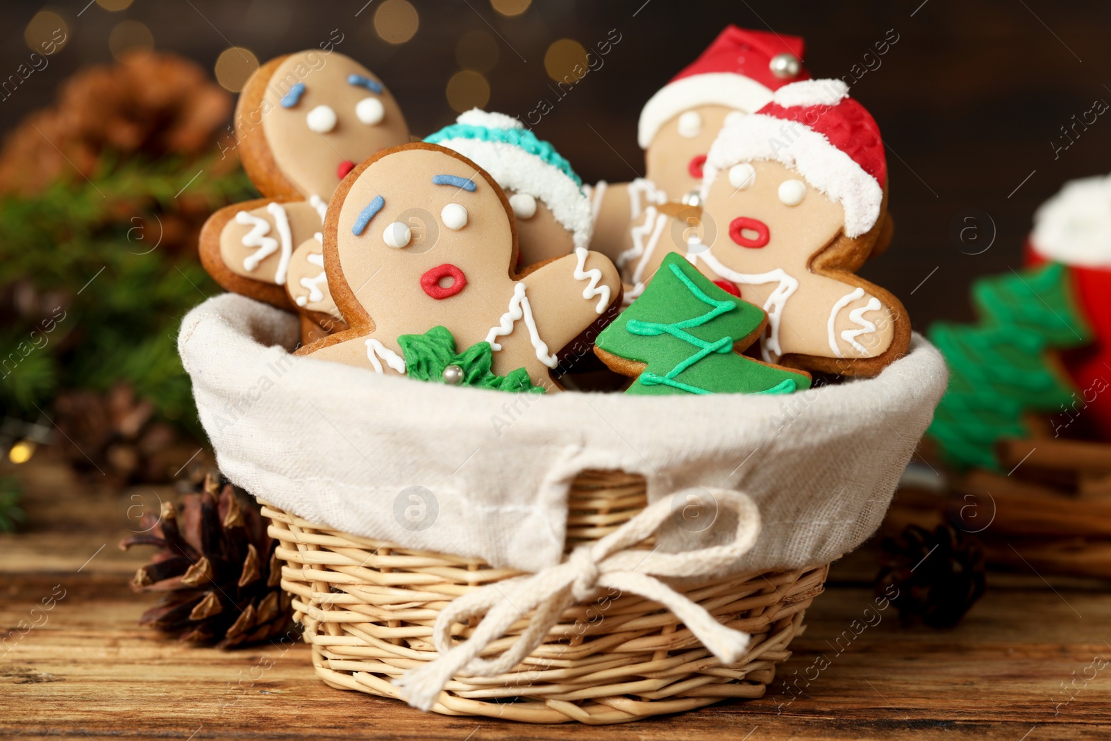 Photo of Delicious homemade Christmas cookies in wicker basket on wooden table