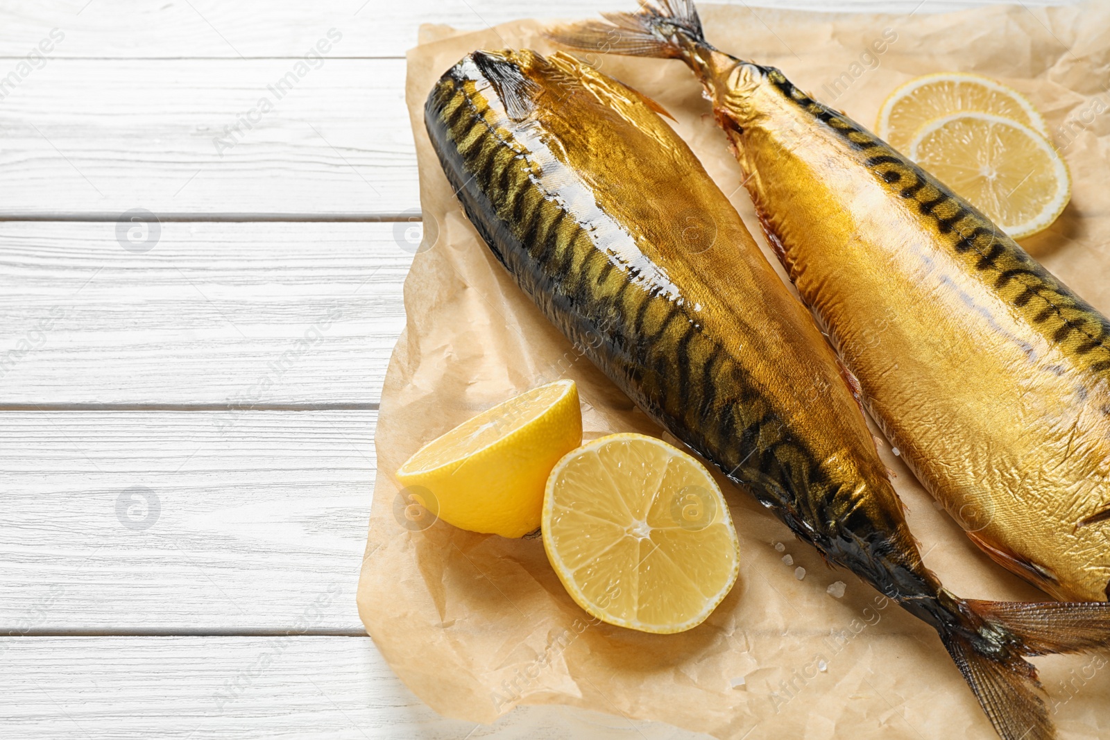 Photo of Tasty smoked fish on white wooden table