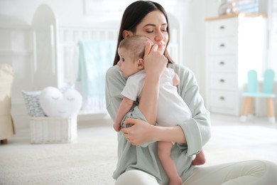 Photo of Young woman with her cute baby at home, space for text