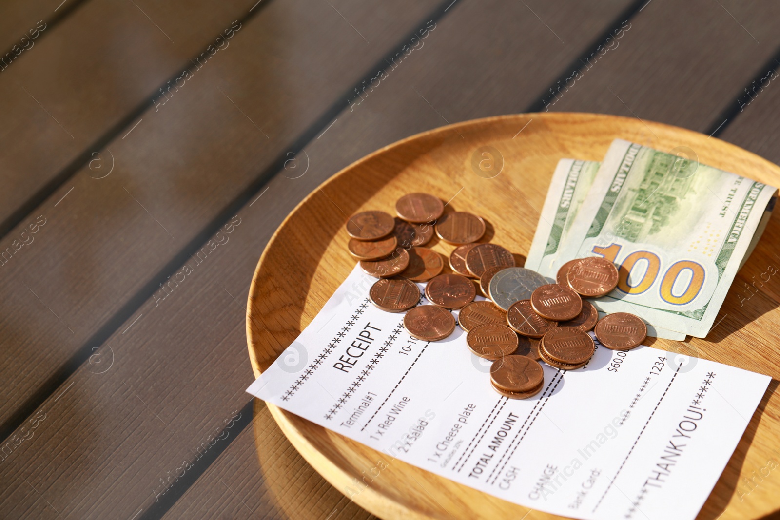 Photo of Wooden plate with payment for order and receipt on table, closeup. Leave tip