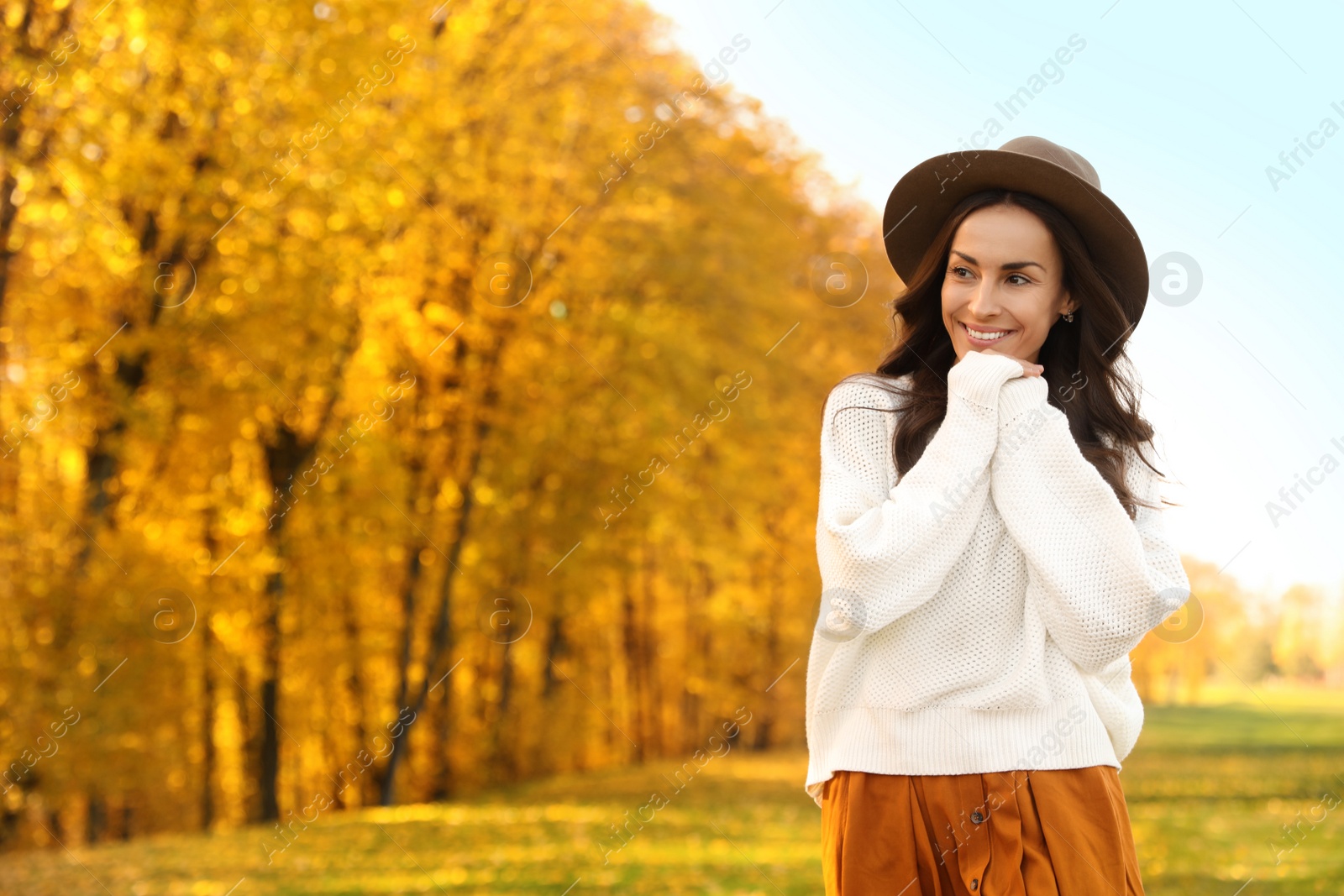 Photo of Beautiful happy woman wearing hat in park. Autumn walk