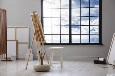 Photo of Stylish artist's studio interior with easel and brushes