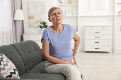 Arthritis symptoms. Woman suffering from hip joint pain at home
