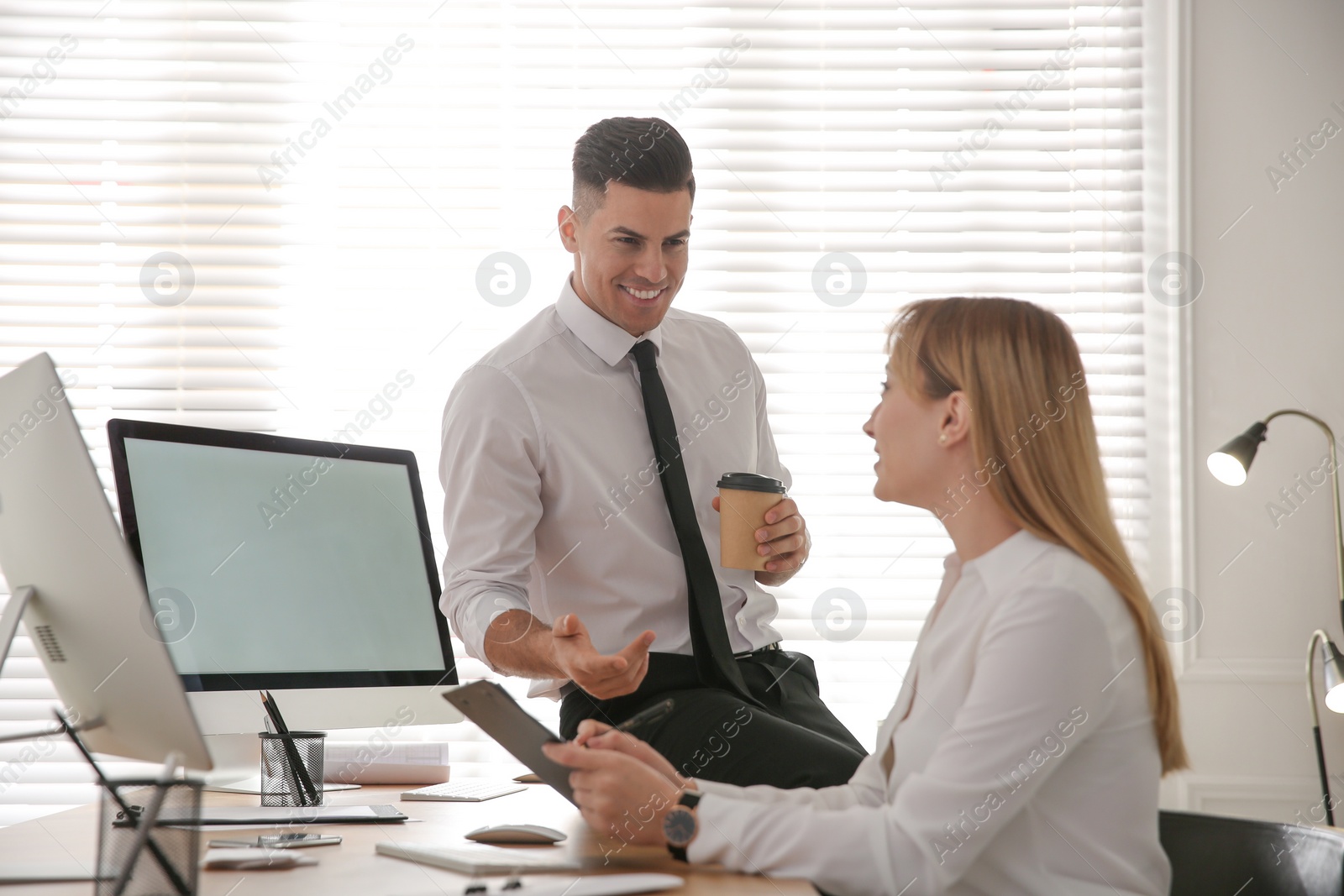 Photo of Man flirting with his colleague during work in office