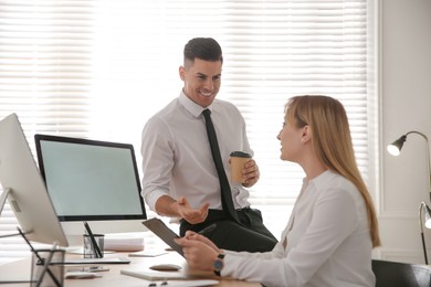 Photo of Man flirting with his colleague during work in office