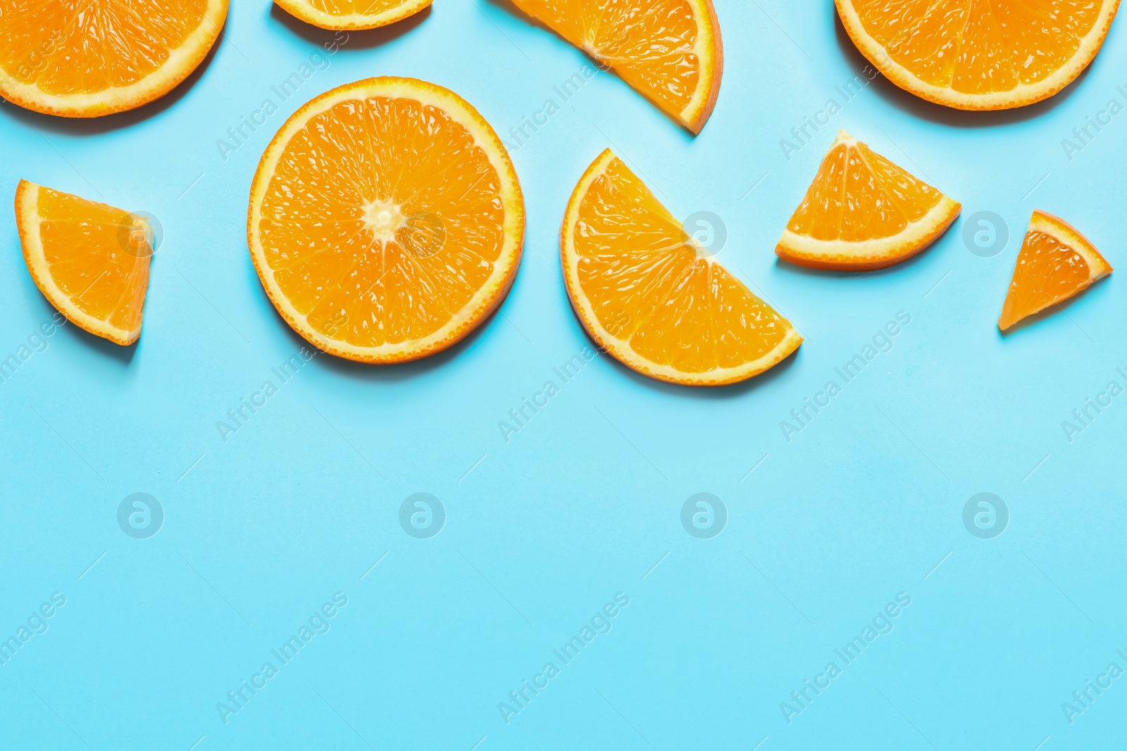 Photo of Flat lay composition with orange slices and space for text on color background