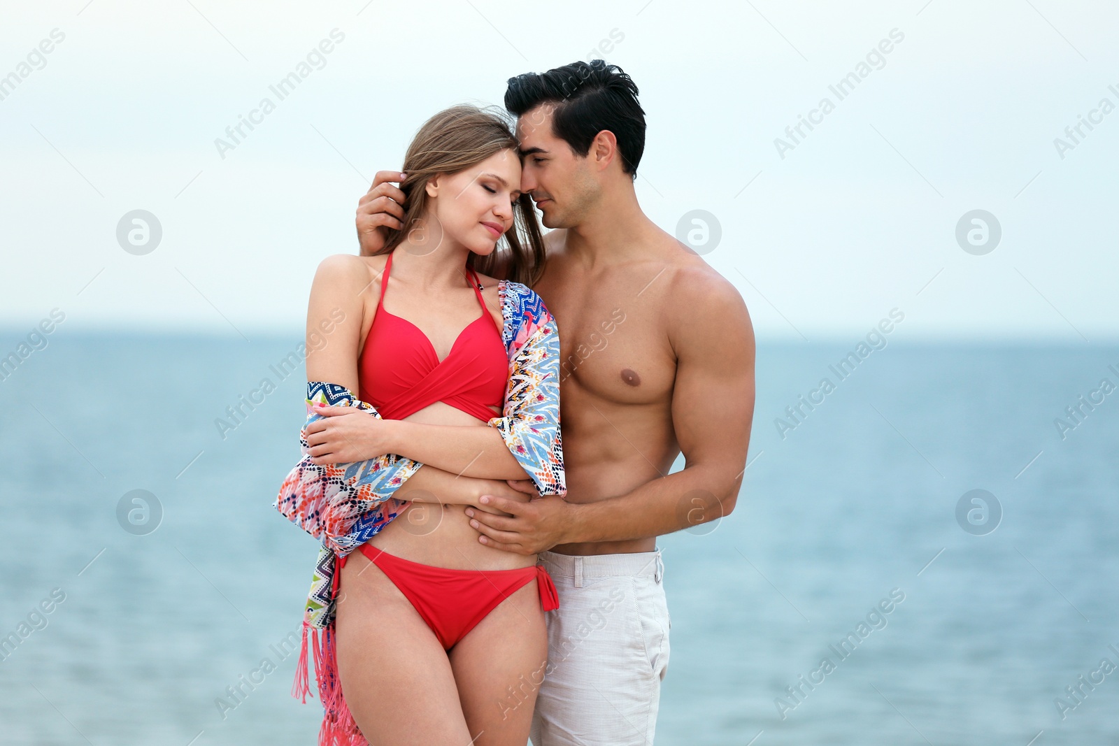 Photo of Happy young couple spending time together on sea beach