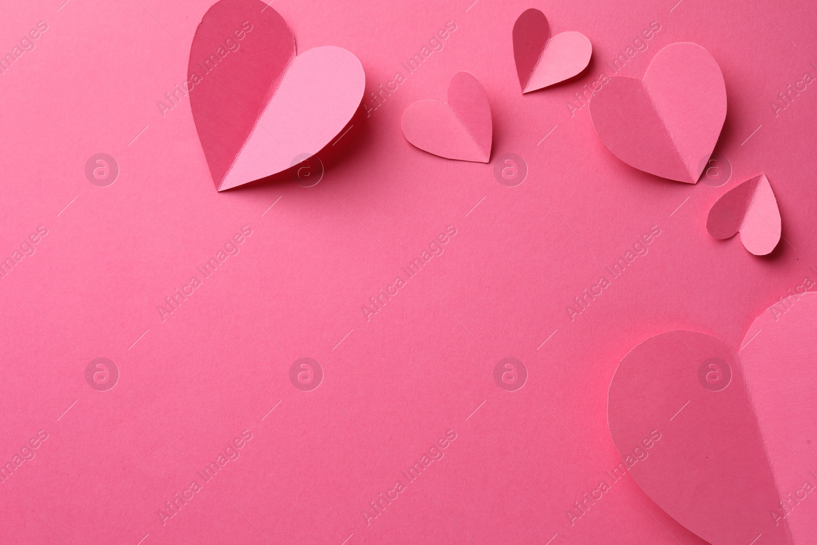 Photo of Paper hearts on pink background, flat lay. Space for text