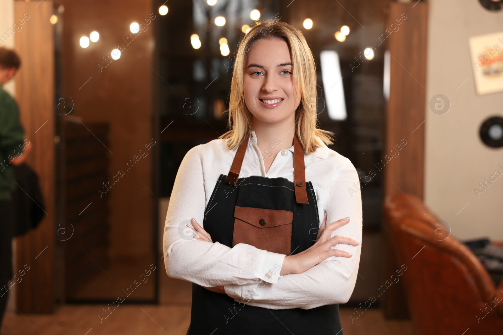 Photo of Portrait of professional hairdresser wearing apron in beauty salon