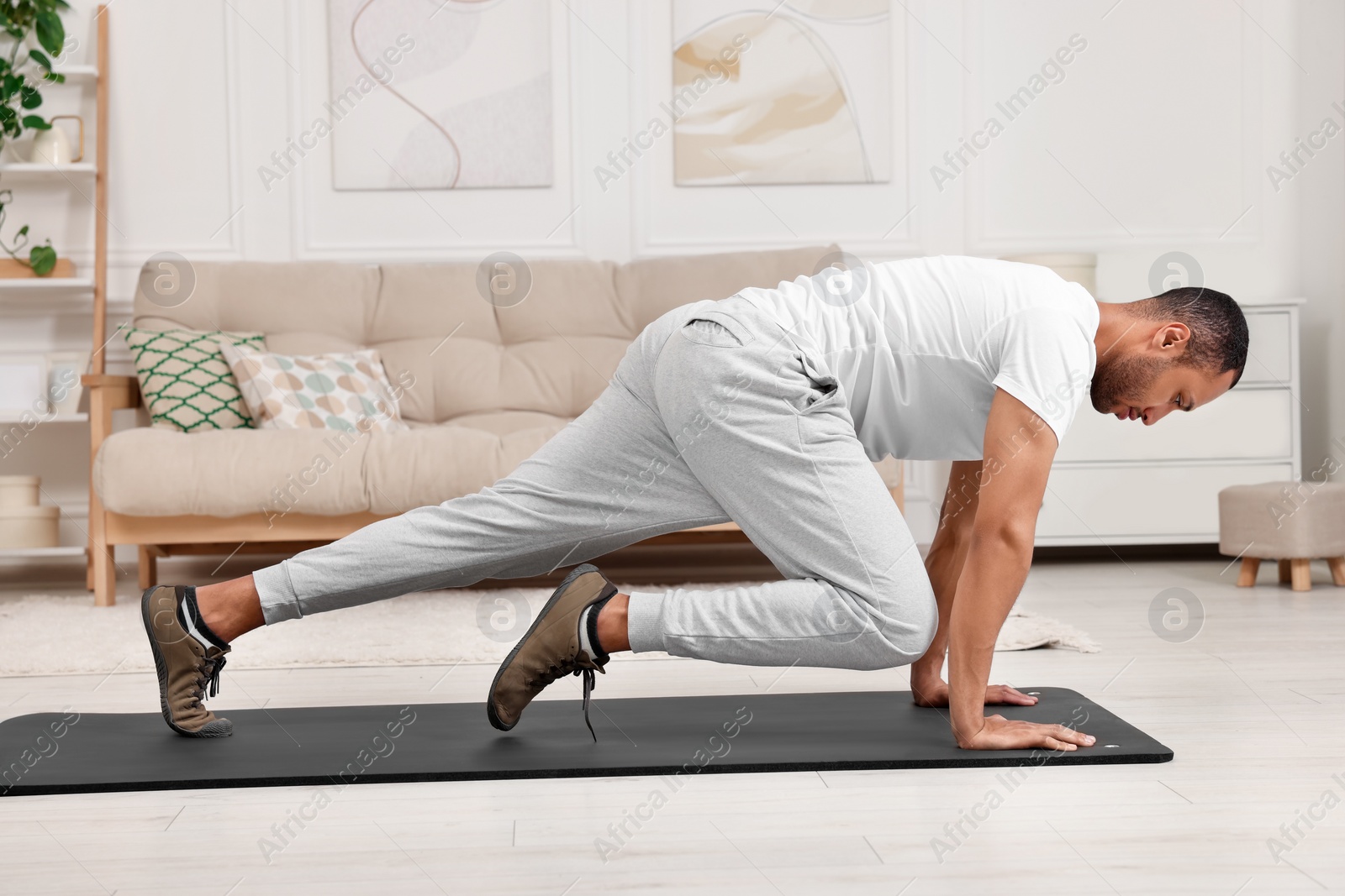 Photo of Man doing morning exercise on fitness mat at home