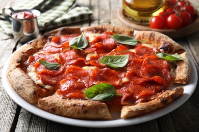 Tasty pepperoni pizza with basil, tomatoes and sauce on wooden table