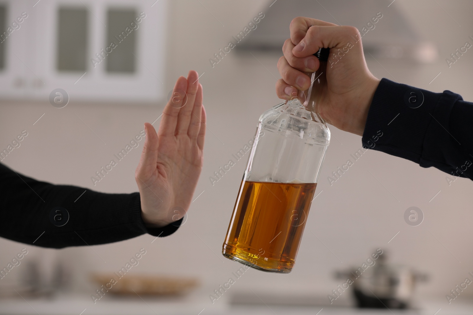 Photo of Woman refusing to drink whiskey in kitchen, closeup. Alcohol addiction treatment