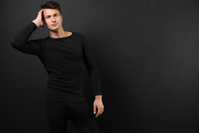 Photo of Man wearing thermal underwear on black background. Space for text