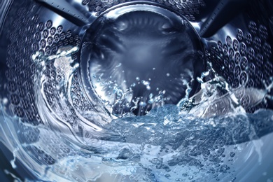 Image of Washing machine drum with water, closeup view