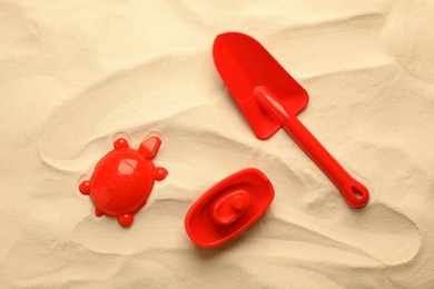 Photo of Beach toy kit on sand, flat lay. Outdoor play