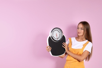 Photo of Slim woman with scale on color background. Healthy diet