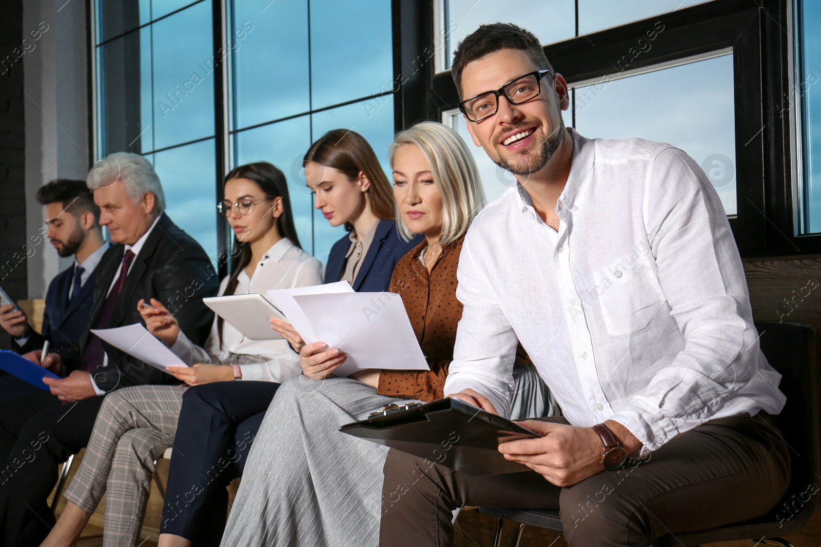 Photo of Man with clipboard waiting for job interview in office hall