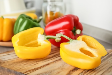 Photo of Wooden board with ripe paprika peppers on table, closeup