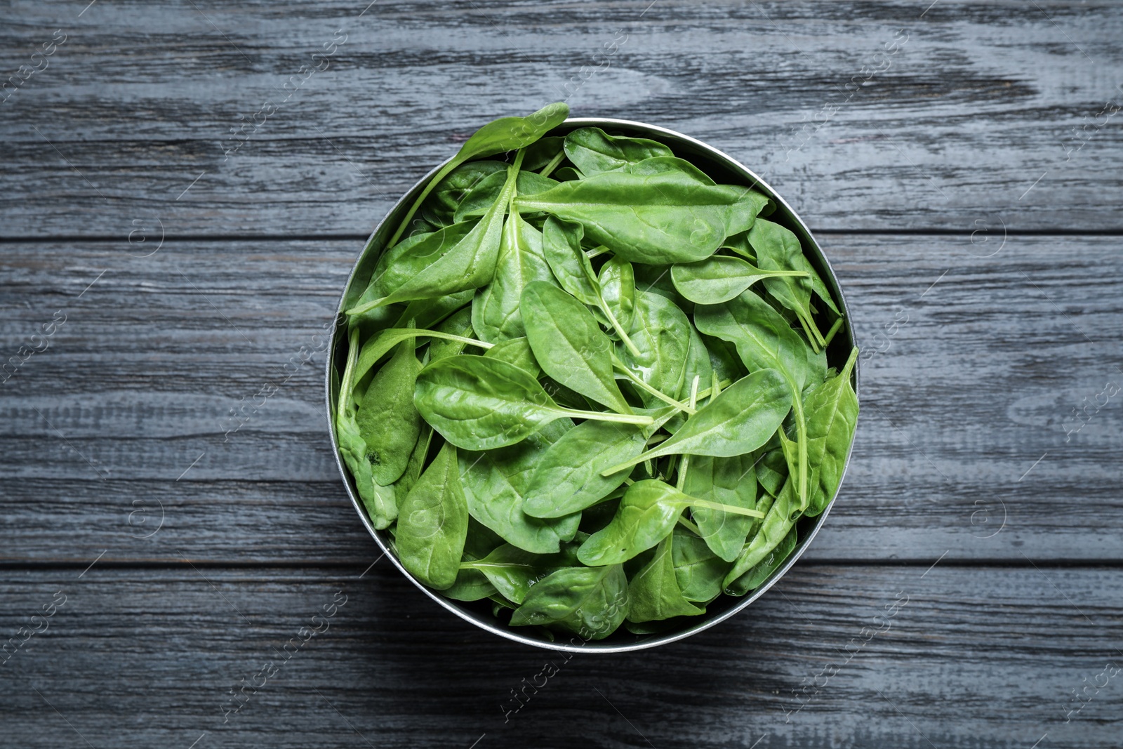 Photo of Fresh green healthy spinach on dark wooden table, top view