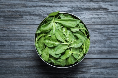 Photo of Fresh green healthy spinach on dark wooden table, top view