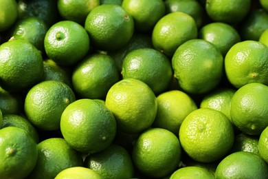 Photo of Fresh ripe green limes as background, closeup