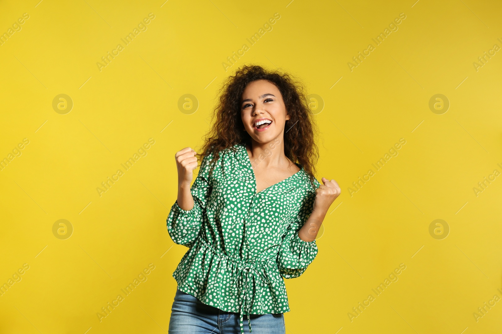 Photo of Portrait of emotional African-American woman on color background