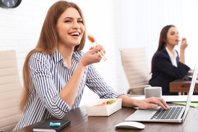 Photo of Office employees having lunch at workplace. Food delivery