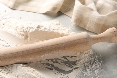 Photo of Pile of flour and rolling pin on grey marble table, closeup