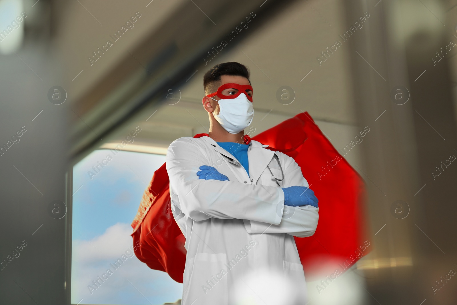 Photo of Doctor wearing face mask and cape indoors. Super hero power for medicine