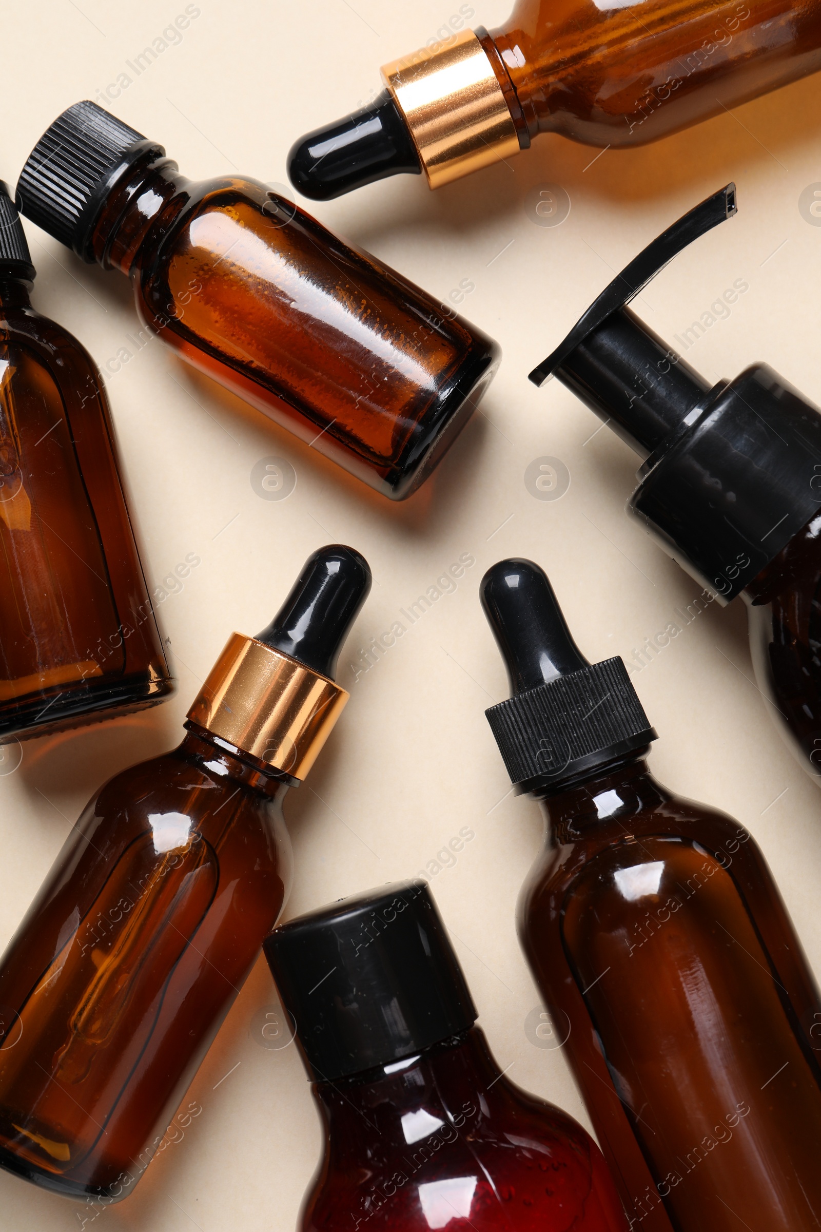 Photo of Face serums and other skin care products on beige background, flat lay